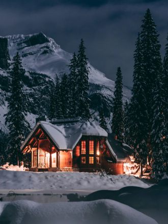 Snow-covered, cozy wooden cabin in the winter